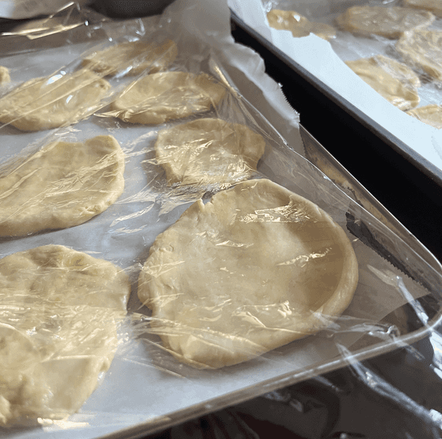 Flat disks left to proof under plastic wrap