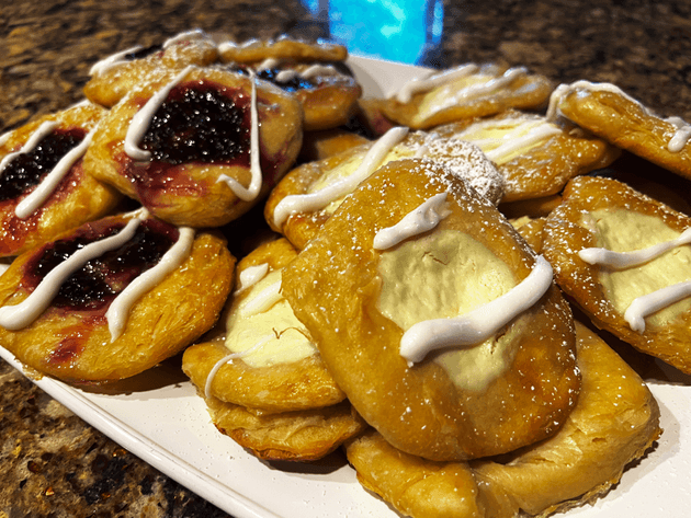 Many Danishes with either a blackberry jam or cream-cheese filling